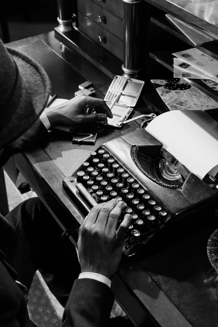 testimonials-img Black and white image of a detective at a typewriter, evoking mystery and noir ambiance.